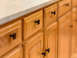 Refaced wood cabinet doors and drawer fronts with updated black cabinet hardware